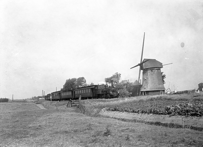 151329 Afbeelding van de stoomlocomotief nr. 7742 (serie 7700, Bello ) van de N.S. met rijtuigen in een landschap met ...